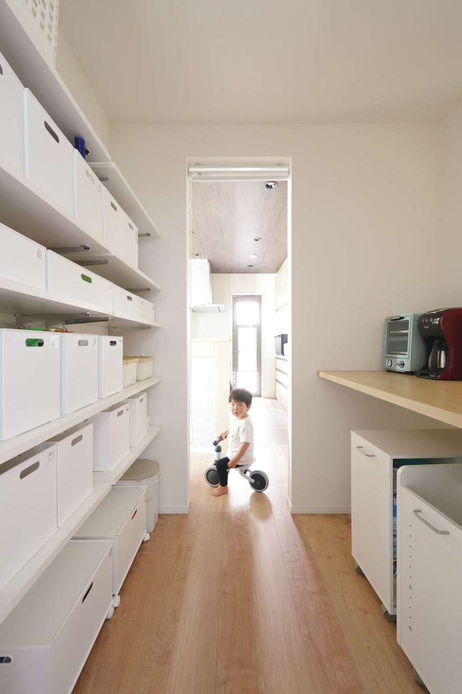 丸昇彦坂建設【デザイン住宅、子育て、間取り】キッチンの横にある家事カウンター付のパントリー。浴室と繋がっていて、玄関にも通り抜けができる