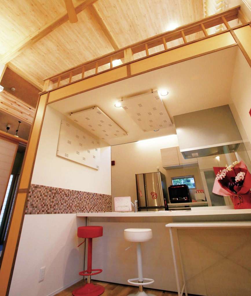 片桐建設【デザイン住宅、自然素材、夫婦で暮らす】キッチンのカウンターには色違いのスツールを設置。キッチン上にはロフトがあり、こちらもお孫さんの遊び場に