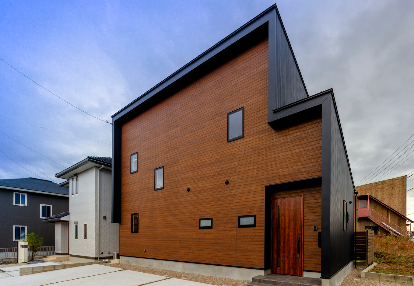長坂篤建築研究所│nalabo（エヌエーラボ）【デザイン住宅、収納力、建築家】ブラックのガルバリウム鋼板と木目調のサイディングが美しく調和した、建築家らしい外観デザイン。変形地を活かした建物の配置、片流れの屋根、木の軒天、窓の位置など、隅々まで緻密に計算されている
