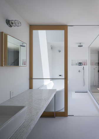 光が差し込む明るい造作のバスルームと洗面