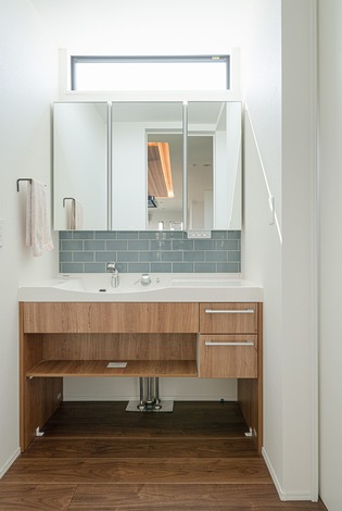 洗面は清潔感の漂うブルーのタイルで装飾。夫婦二人で並んでも余裕がある
