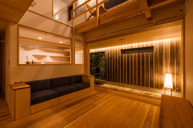 KEN建築工房｜落ち着いた照明が心地よい和モダンなリビングダイニングキッチン。木材を多用した空間で、温かみを感じる落ち着いたインテリアが特徴。家具の配置が工夫され、開放感を演出しています。