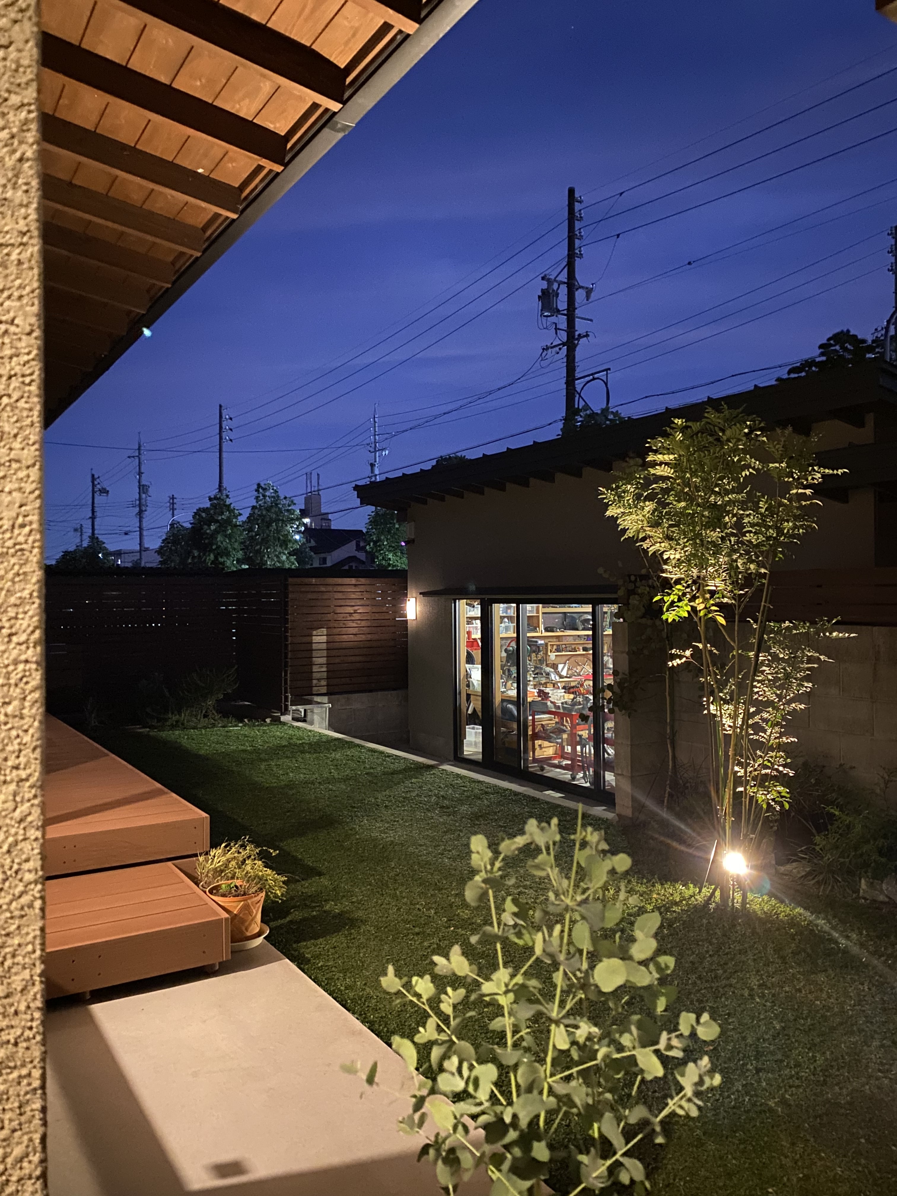 安田住宅｜安田建築設計室｜夕暮れ時にライトアップされた庭の風景。心地よい空間が広がり、落ち着いた雰囲気を演出している。