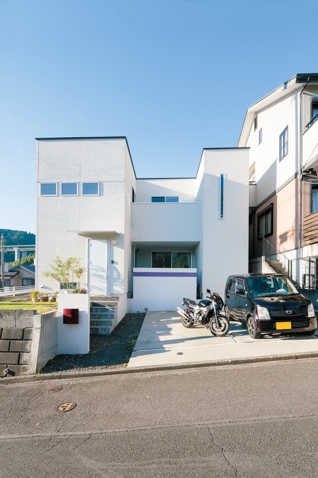 外観も白で統一。テラスに設置した壁にも、奥さまの好きな色でラインをつけアクセントに