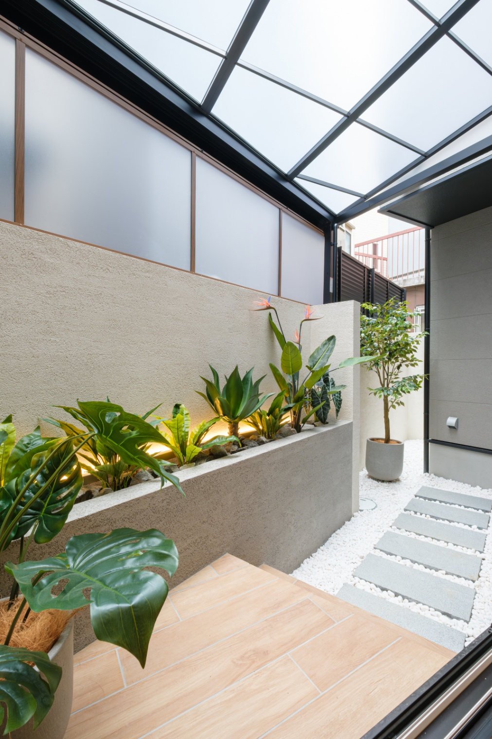 新栄建設｜寝室の掃き出し窓の向こうには屋根付きの庭。植栽と敷石が整然と並べられ、半屋外のリラックススペースとして活用できる設計が魅力。