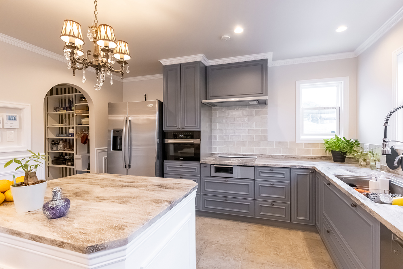 ジェネラルアメリカンホーム【輸入住宅、ペット、ガレージ】天然石の作業台やミレーの食洗機を備えたオーダーメイドのキッチン。パントリーの入口をアーチ型にしたのもこだわり