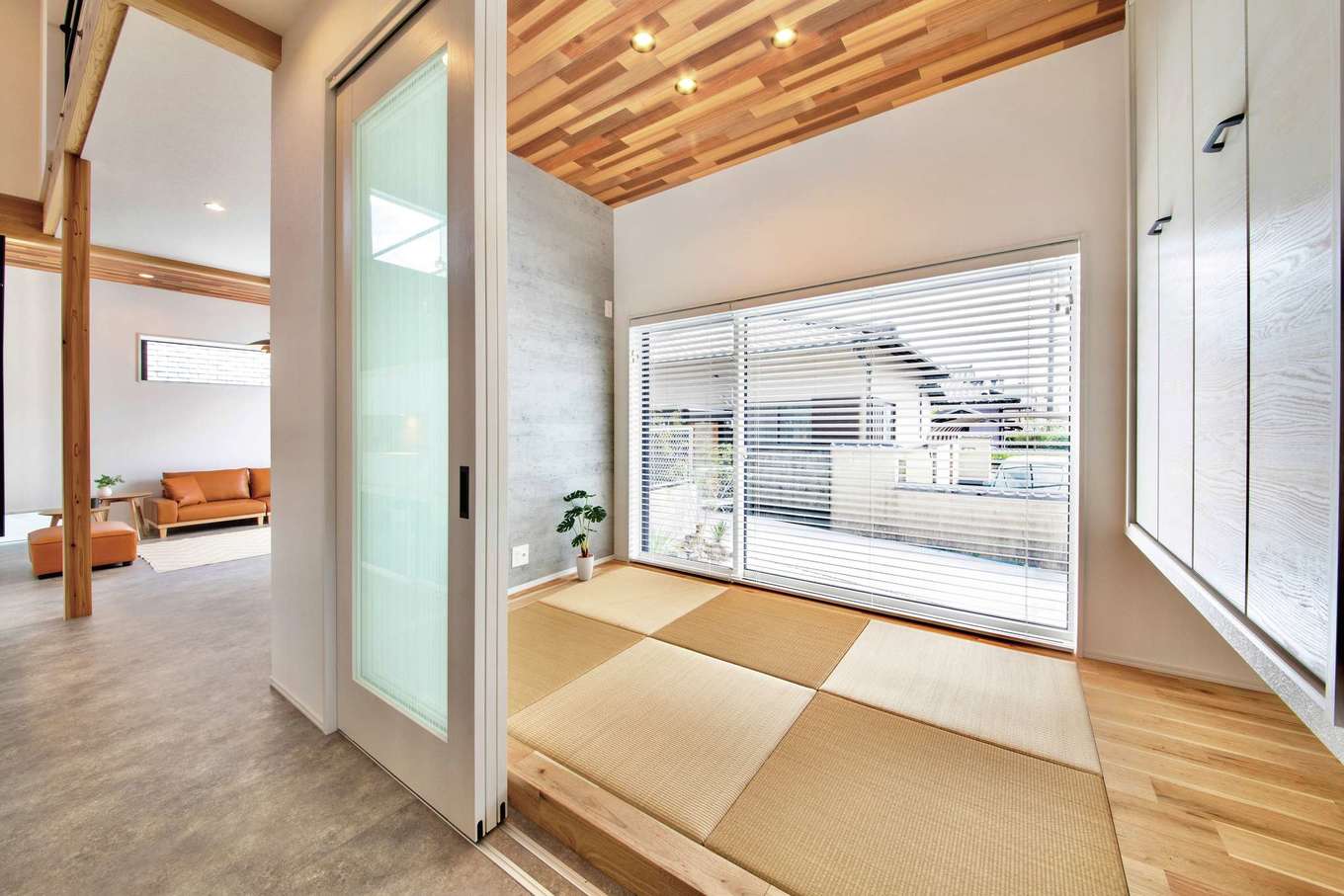 住たくeco工房【間取り、スキップフロア、ガレージ】リビングと隣接する和室。FIX窓を大きくとり、吊り押入れで広く見せている。間仕切りもできるので、ゲストの寝室としても使える