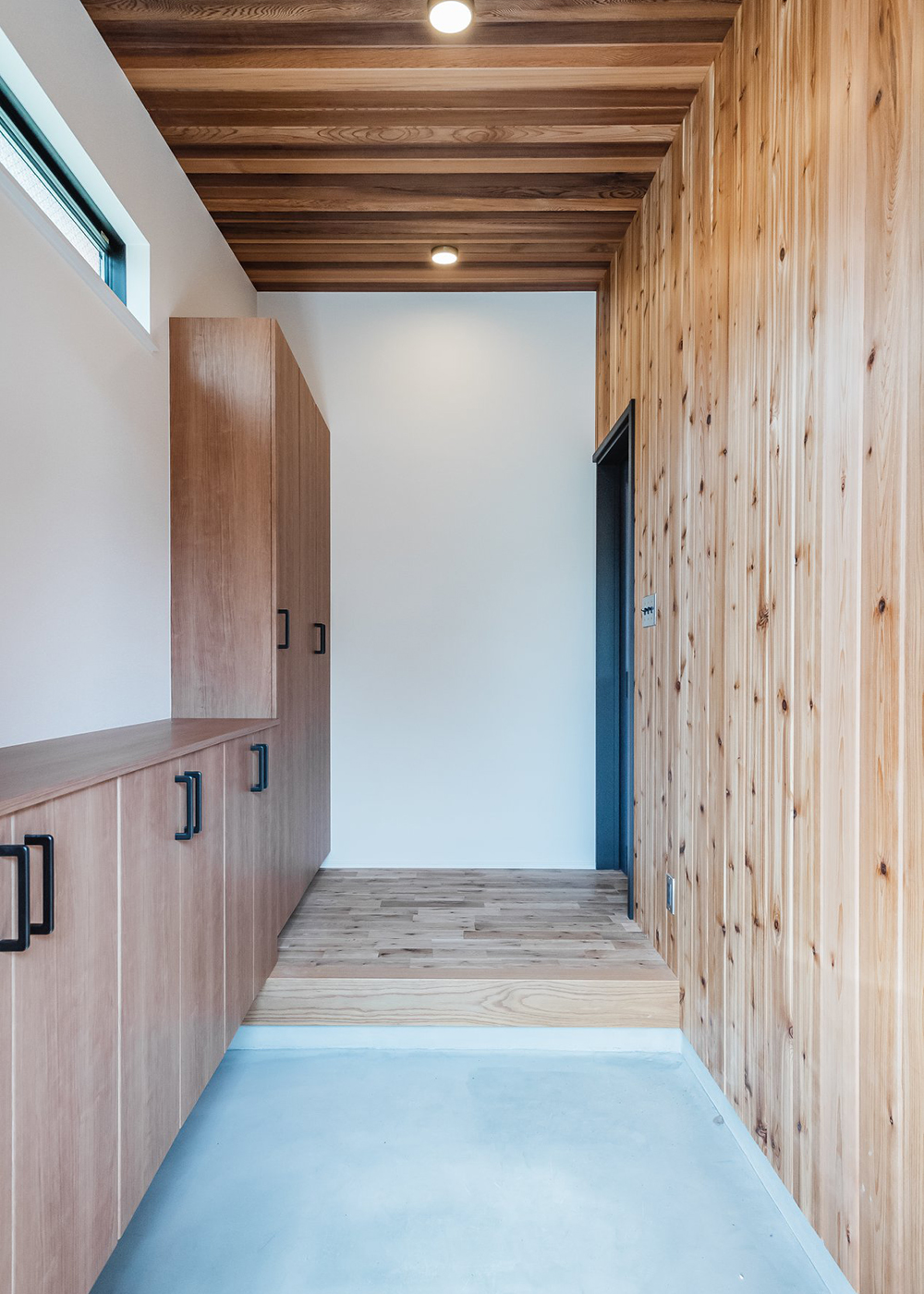 オレンジハウス【デザイン住宅、子育て、間取り】天井と壁、建具に木をふんだんに使った玄関ホール。シューズクローゼットと玄関収納は造作