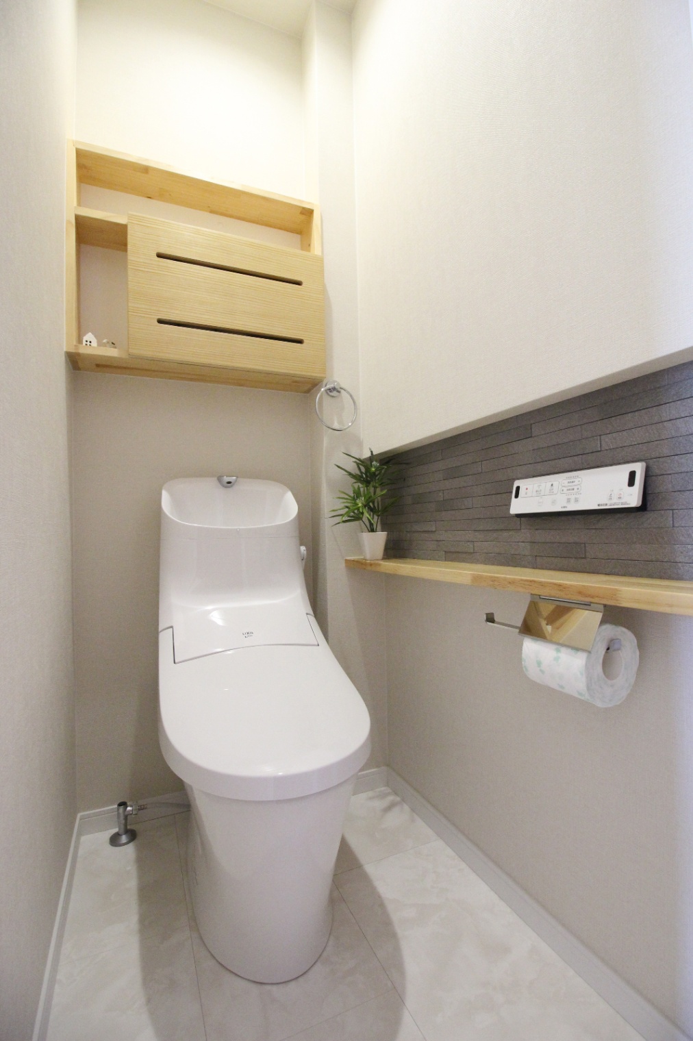 小野田産業～designers house project～｜コンパクトでありながら機能的なデザインのトイレ。落ち着いた色合いの壁とシェルフがアクセントになり、快適な空間を演出する。