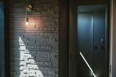 中庭に面したFIX窓の壁に凸凹感のあるタイルを貼って高級感を演出。間接照明もベストマッチ