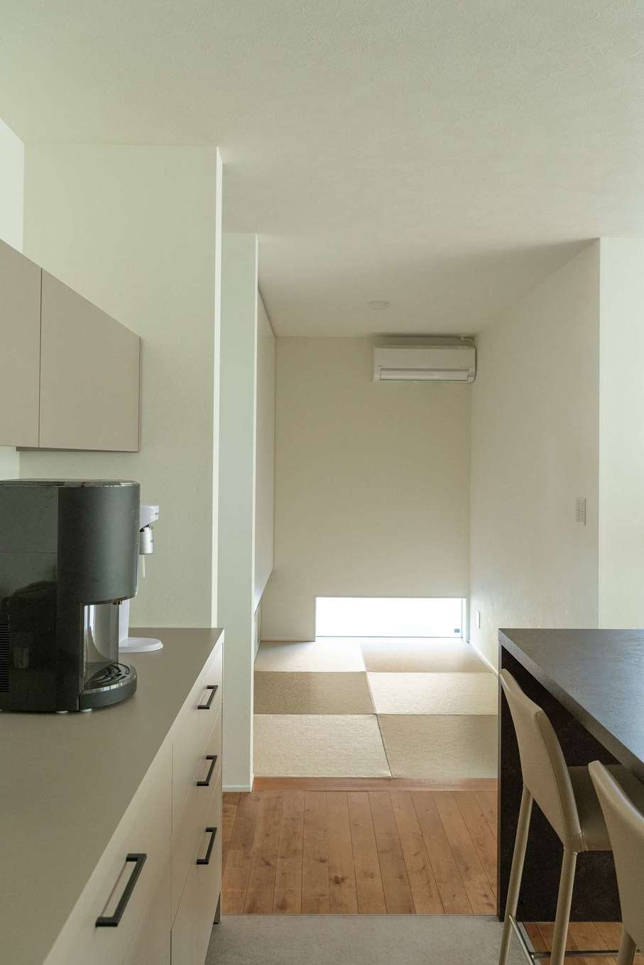 ハウスプラン（R＋house沼津・富士）【デザイン住宅、省エネ、建築家】キッチンから目が届く位置に和室を配した。夏はこのエアコンが、LDKから寝室までを快適に過ごせる室内温度にしてくれる