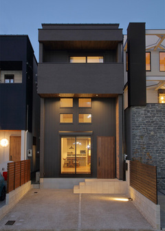 ２種類の素材でデザインされたグレー配色の外観。2階の家ながら3階建ての高さで設計されているため風格もある。一階上部に窓を取り付けられるのは、吹き抜けだからこそ。光が入りやすく家の中が明るい