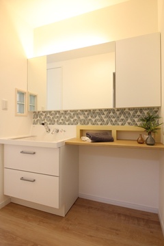 広々とした洗面スペース。シンプルになりやすい洗面台も間接照明や小窓、造作のカウンターで一気にお洒落に。アクセントのタイルで可愛らしい空間に仕上がった。