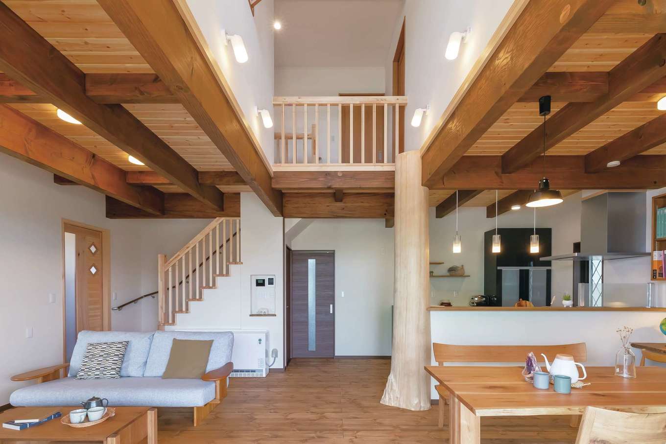 住まいるコーポレーション【子育て、自然素材、省エネ】リビングとダイニングを吹抜けでゾーニングしたLDK。天井の梁は濃い茶色の自然塗料で着色し、レトロ感を演出。スギの大黒丸太柱が存在感を放ち、家族の暮らしをやさしく見守ってくれているかのよう