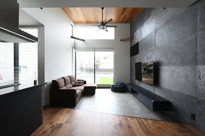 大きな窓から自然光がたっぷり差し込むリビング。壁面には石材が使用され、モダンな印象を与えている。