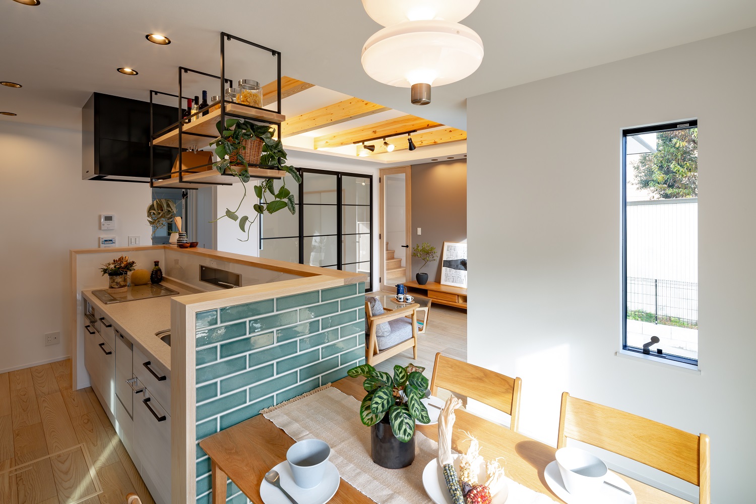 ムニカデザイン（まほろばホーム）｜訪れるお客様を驚かせる、グリーンタイルのアイランドキッチンは圧巻。