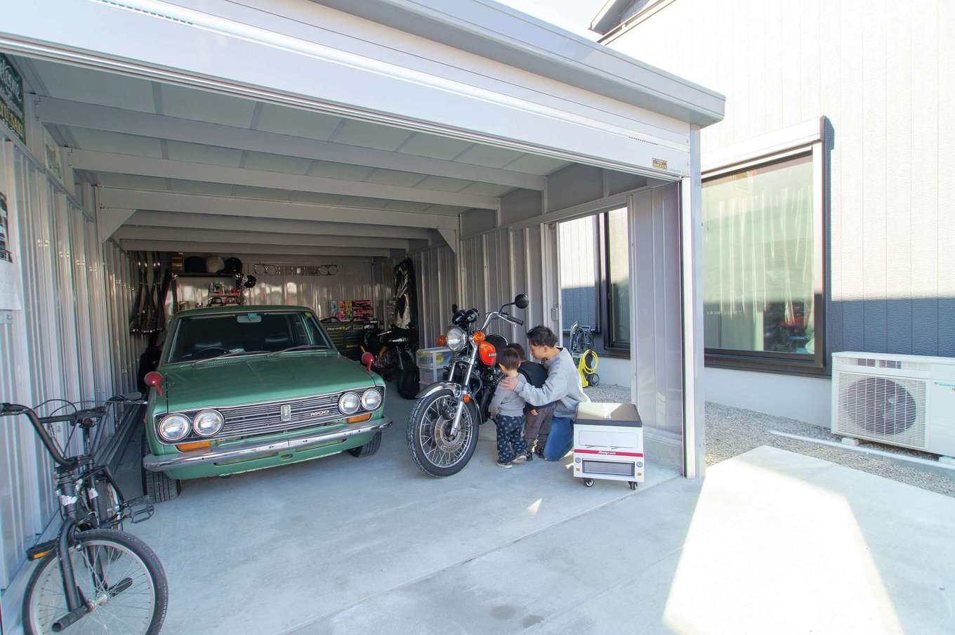 さくらホーム【趣味、ガレージ、鉄骨鉄筋コンクリート構造】趣味の愛車とバイクを守るガレージ。建物側に設けた開口部がリビングとのつながりを生む