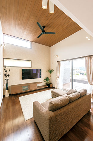 -delphi- デルフィ（藤井建築事務所） 【デザイン住宅、間取り、建築家】テレビの後ろの壁はエコカラットで高級感を演出。床の色に合わせた木の天井＆シー リングファン、宙に浮いたような造作テレビボードがスタイリッシュ