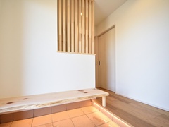 ナチュラルな木材を使用した玄関ホール。木製のベンチが特徴的で、家に入るときにホッと一息つける憩いの場