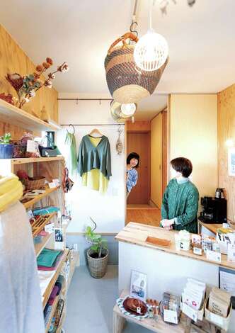 入政建築｜会計カウンターの奥は住居への出入り口があり、子どもたちがママの様子をのぞきにくる