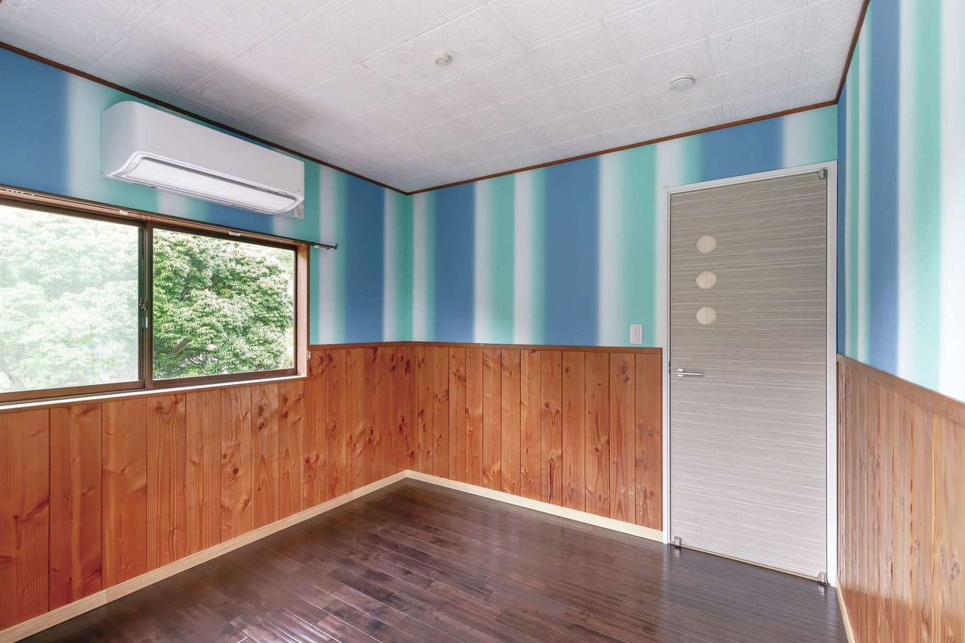 nattoku住宅｜子ども部屋の腰壁は既存のものをそのまま活かし、床は無垢に変え、クロスは長女に選ばせて張り替えた。ドアも船室のイメージに合わせてチョイス