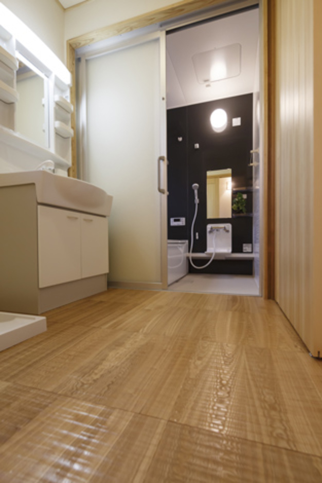 浴室は脱衣室との段差がないバリアフリー。タモ材のスプーンカット仕様の床は、歩いた時の当たりが柔らか