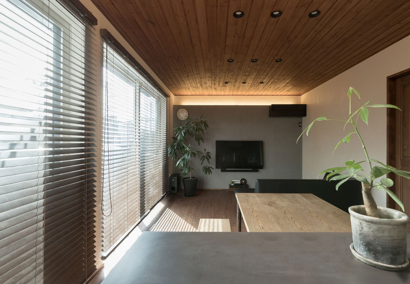 アイジースタイルハウス【デザイン住宅、高級住宅、ガレージ】モノトーンの配色が落ち着いた雰囲気のリビング・ダイニングスペース。ブラインドや観葉植物がよく似合う