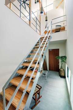 素材感を活かしたスチール階段や見せるシューズラックが空間のアクセント