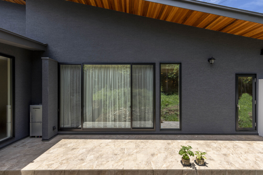 チェックハウス｜木製の床が印象的なテラス。外壁とのコントラストが美しく、外の景色を楽しめる。