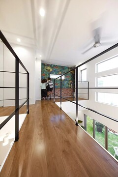 ご主人もお気に入りのひとつと語る渡り廊下。家全体が遊び場かのように子供たちが走りまわるその先には、シンプルな家づくりにアクセントを与えてくれるこだわりのクロスが貼られたフリースペースが。目線の先に変化をつけて、歩くだけでも気持ちの良い工夫が施されています。