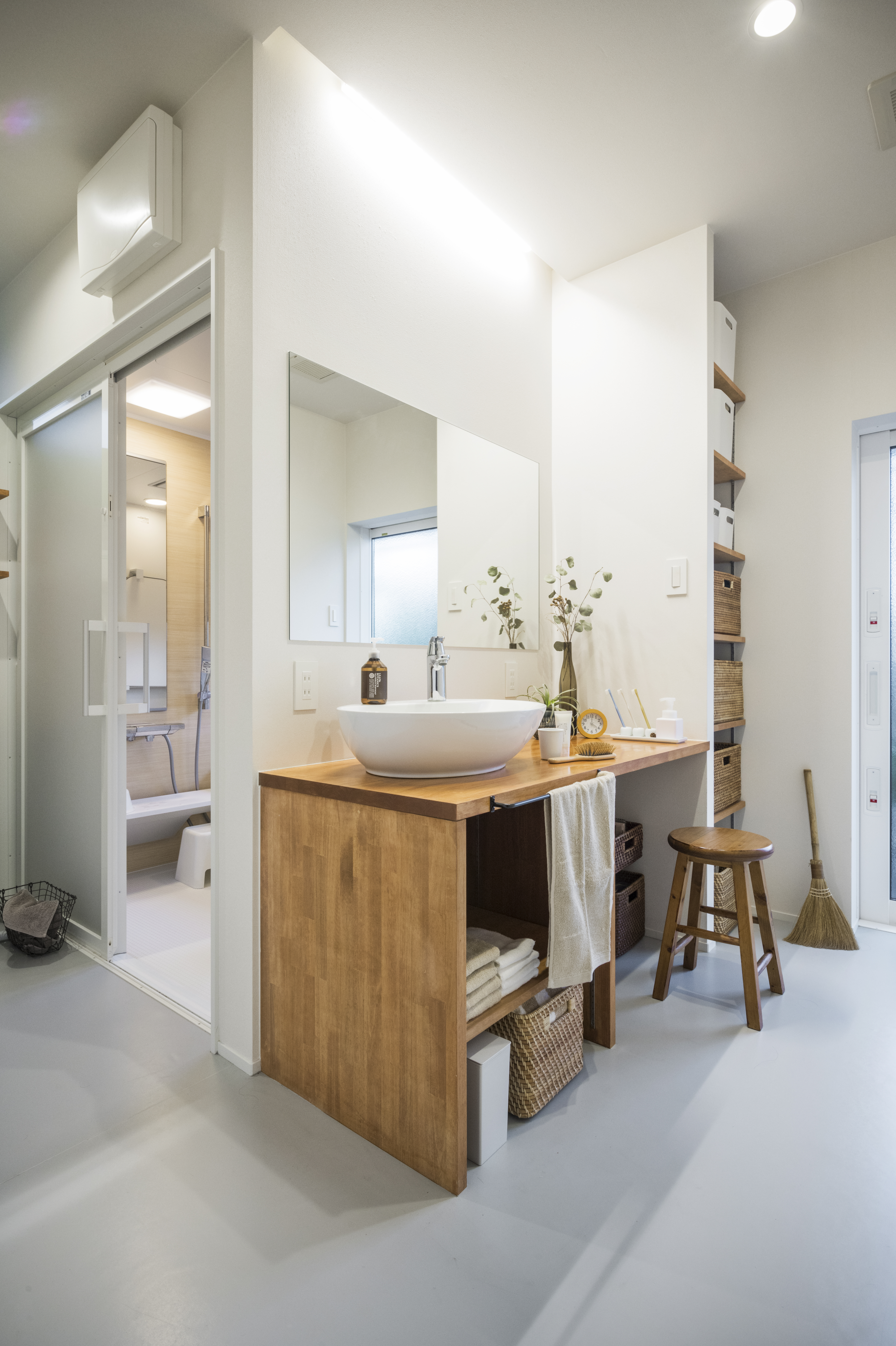 グランハウス一級建築士事務所｜洗面はデザインは損ねない範囲で使い勝手を重視。座って身支度できるスペースの横には大容量の収納がある。
