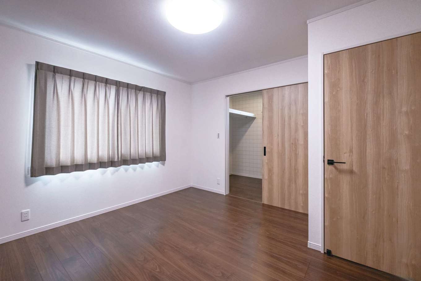 ＩＤＫ 住まいの発見館【1000万円台、省エネ、間取り】3畳のウォークインクローゼット付きの寝室。全体は落ち着いた雰囲気だがクローゼットの中だけチェックの柄クロスで変化をつけた