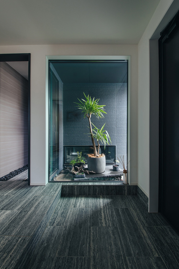 大きなFIX窓から中庭へと目線が抜ける玄関ホール。独創的な演出で非