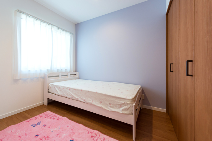 明るい自然光が射し込む子ども部屋。シンプルな白いベッドとやさしいカラーの壁が、リラックスできる空間を演出している。大容量のクローゼットも完備。