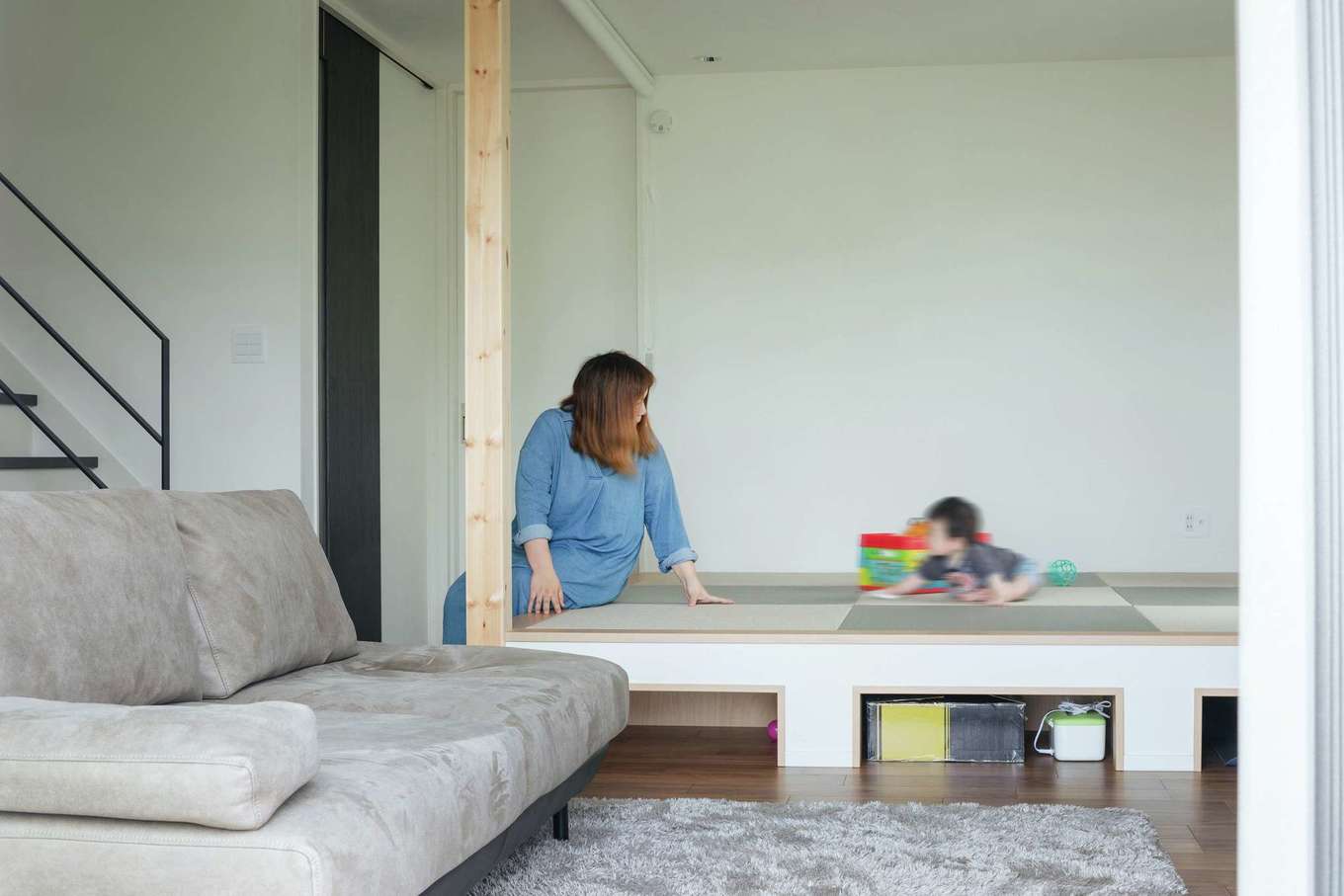 子育て安心住宅 Design Craft Office【デザイン住宅、省エネ、間取り】子どものおもちゃ遊びやお昼寝にも重宝する小上がり。下には収納を設けてあり、お掃除ロボット専用の収納スペースも確保。ロールスクリーンで空間を仕切ることもできる