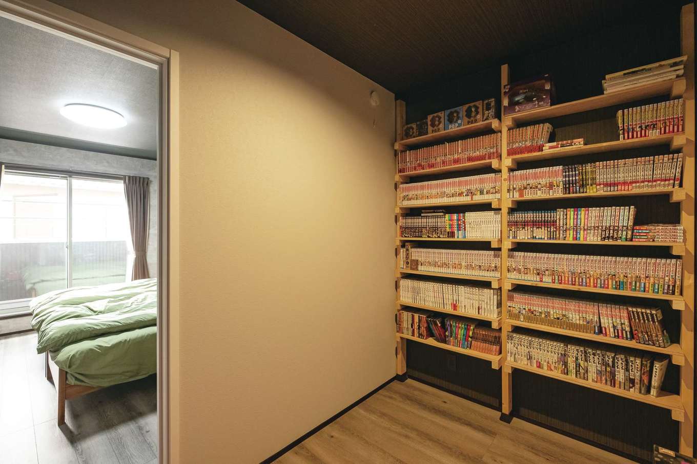 静鉄ホームズ【インテリア、デザイン住宅、子育て】寝室に隣接するご主人の隠れ家的書斎。造作の書棚には漫画本がぎっしり。収納スペースも兼ねている