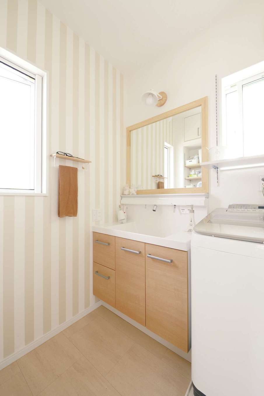 ほっと住まいる【子育て、自然素材、間取り】ストライプの壁紙と、造作した大きな木製枠の鏡がおしゃれな洗面脱衣室