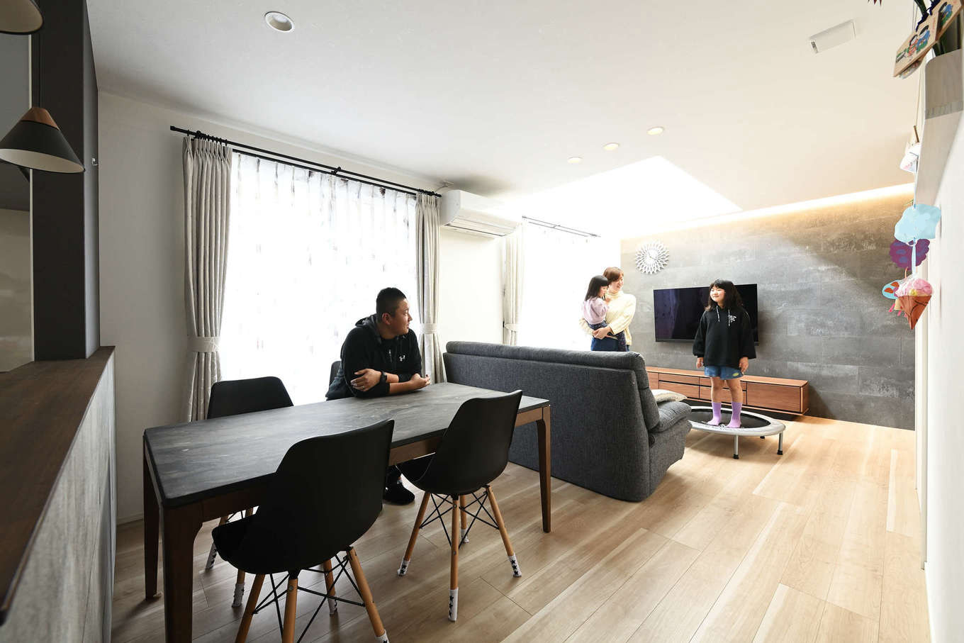 トーリンホーム【デザイン住宅、子育て、間取り】リビングの吹き抜けから光が注ぐLDK。玄関とつながる「ソリド」のアクセントウォールが室内をスタイリッシュモダンに演出