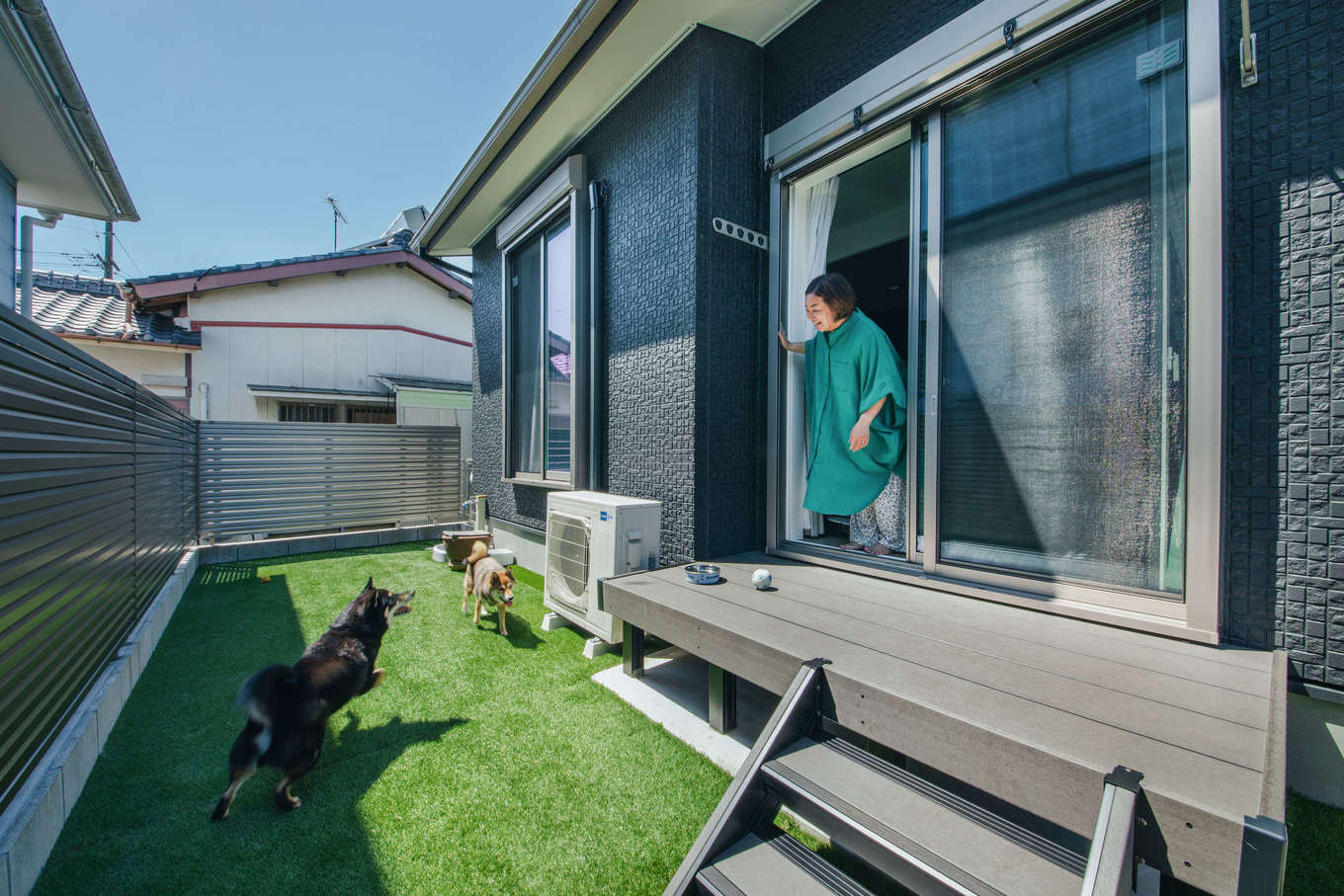 エフエフ住宅【ペット、平屋、スキップフロア】人工芝を敷いてフェンスを高めに設け、ドッグランとしても使える庭が完成。ウッドデッキに出て愛犬たちが庭で遊ぶ様子を眺めながら、のんびり過ごすのが楽しみになった