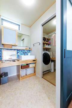 クラッシュタイルが映える造作の洗面台。隣はランドリー