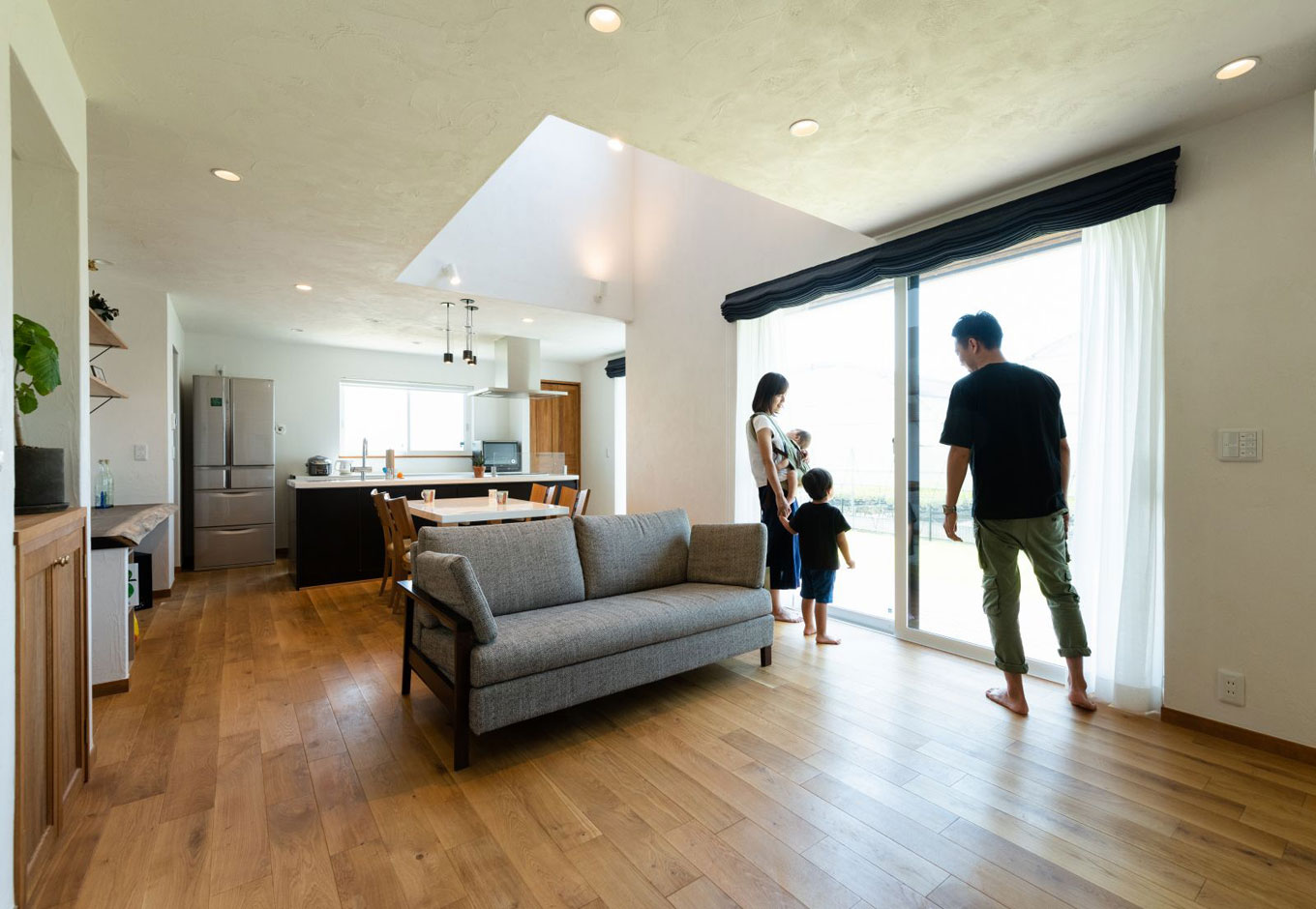 アイジースタイルハウス【デザイン住宅、自然素材、間取り】大きな窓と吹き抜けで明るい光が差し込むリビングスペース。窓の外はレッドシダーのウッドデッキ