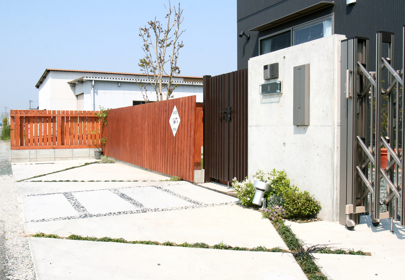 丸昇彦坂建設【デザイン住宅、収納力、和風】石や格子を組み合わせた門構えが家の外観にぴったり。シンプルながら季節感を感じられるたたずまいに