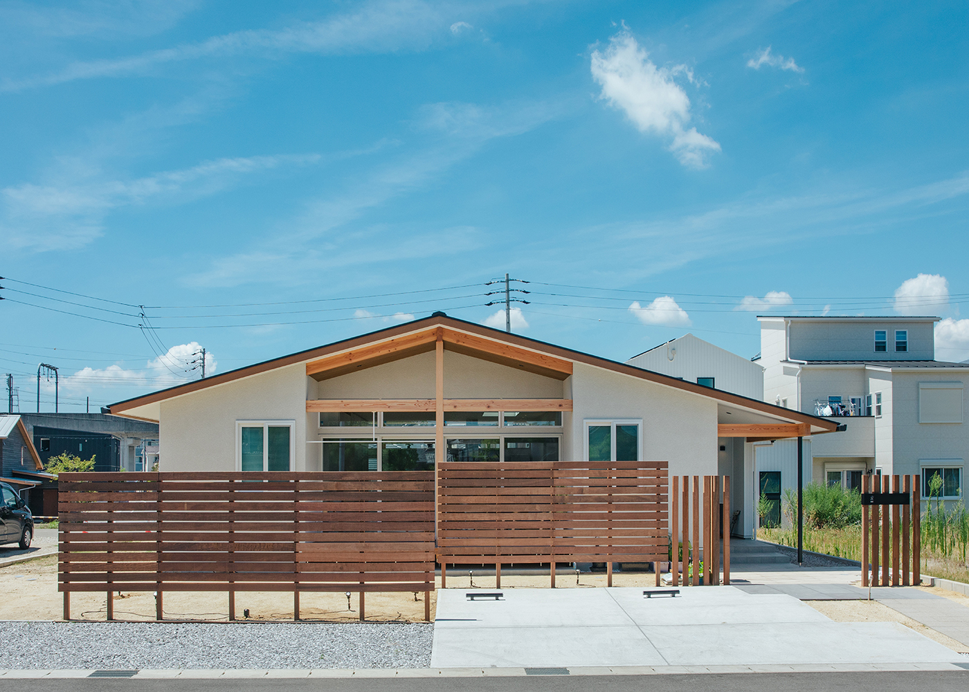 小幡建設【デザイン住宅、収納力、趣味】「ザ・平屋」と呼びたくなる端正な外観デザイン。交通量の多い交差点に面しているため、格子塀で目線を緩やかに遮る。料理教室としてもさり気なく目を引くよう、アプローチが印象に残るように設計されている