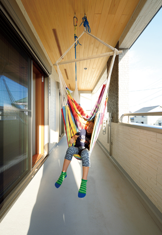 瀧口建設【自然素材、省エネ、間取り】深い軒のバルコニーにハンモックを吊り下げて、長男もゴキゲン！