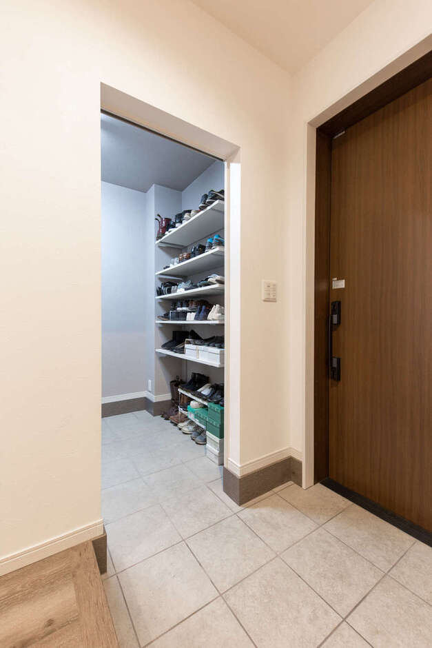 白を基調にした玄関ホール。土間収納は、アウトドア用品をたっぷりと収納できるゆとりの3畳。反対側には、ちょっと腰掛けられるベンチを造作
