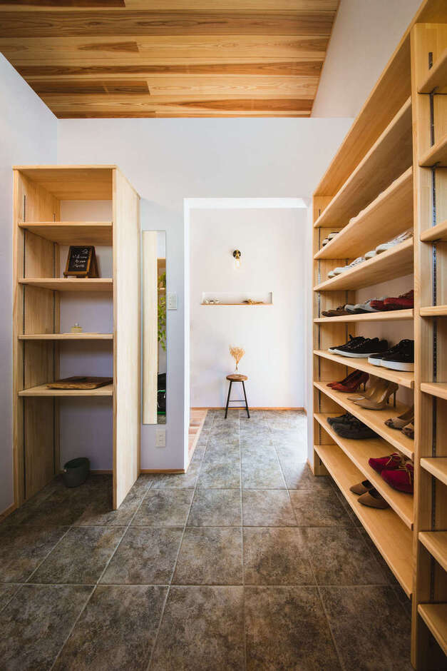 土間仕上げのゆったりとした玄関ホール。女子率が高いので、シューズクロークを大きめに造り、全身鏡も設置した。ここからLDKに直接アクセスできる便利な動線が魅力