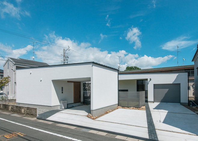 電動シャッター付きのビルトインガレージにご主人の愛車を収納し、玄関前のインナーガレージには奥さまの車をとめている。外壁にはドイツ製Sto（シュトー）の塗り壁を採用。割れや汚れを抑えながら美しい姿を保つ