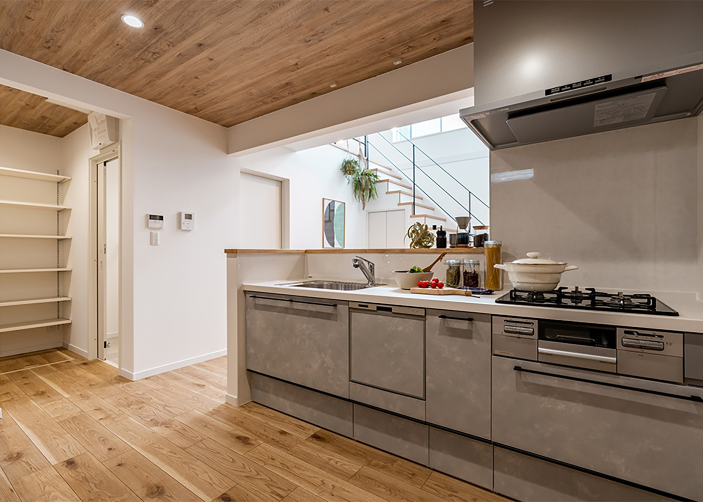 オレンジハウス【デザイン住宅、自然素材、間取り】リビングとつながりを持たせつつ、独立したキッチン。天井にも木を貼って温かい雰囲気に。ここからパントリー、水回りへと連続してつながる「神動線」を実現した