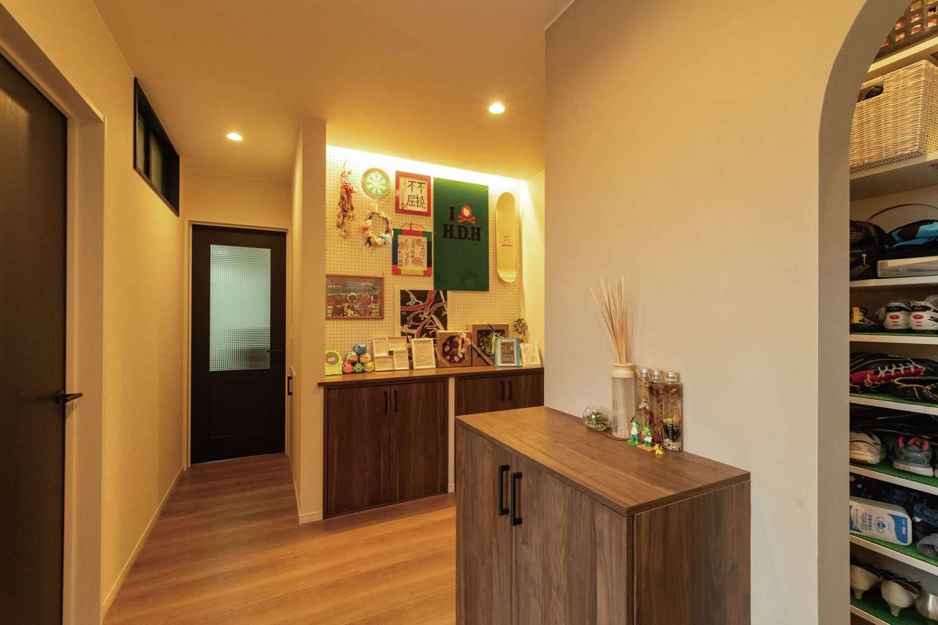 臼幸産業【デザイン住宅、子育て、間取り】お客様用と家族用の2WAY仕様。LDKに繋がる通路が2本あり、全体として大きな回遊動線となっている。玄関のニッチに有孔ボードを設置。子どもの作品を飾れるスペースに