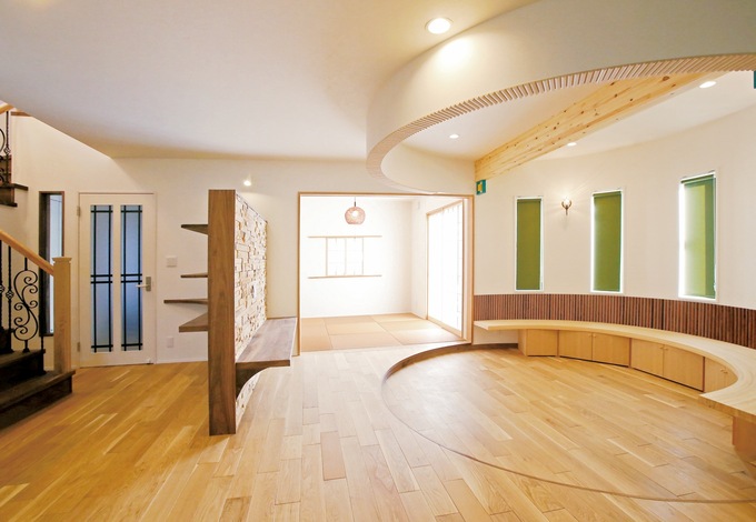 LDKに設けた円形のリビングスペースの壁際には、収納としても活躍するベンチを造作。直線と曲線の巧みな組み合わせで飽きのこないデザインの空間となった